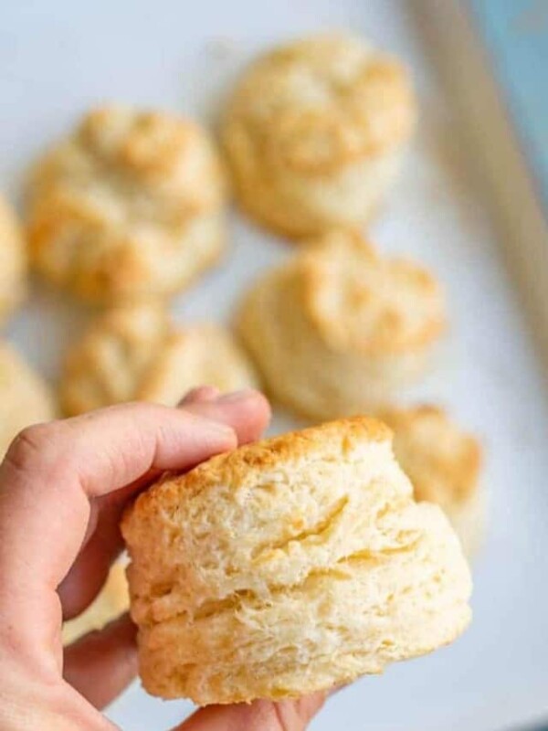 a hand holding a buttermilk biscuit