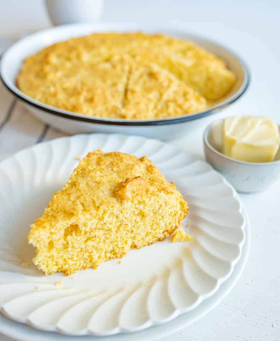 easy sour cream cornbread slice on white plate and butter