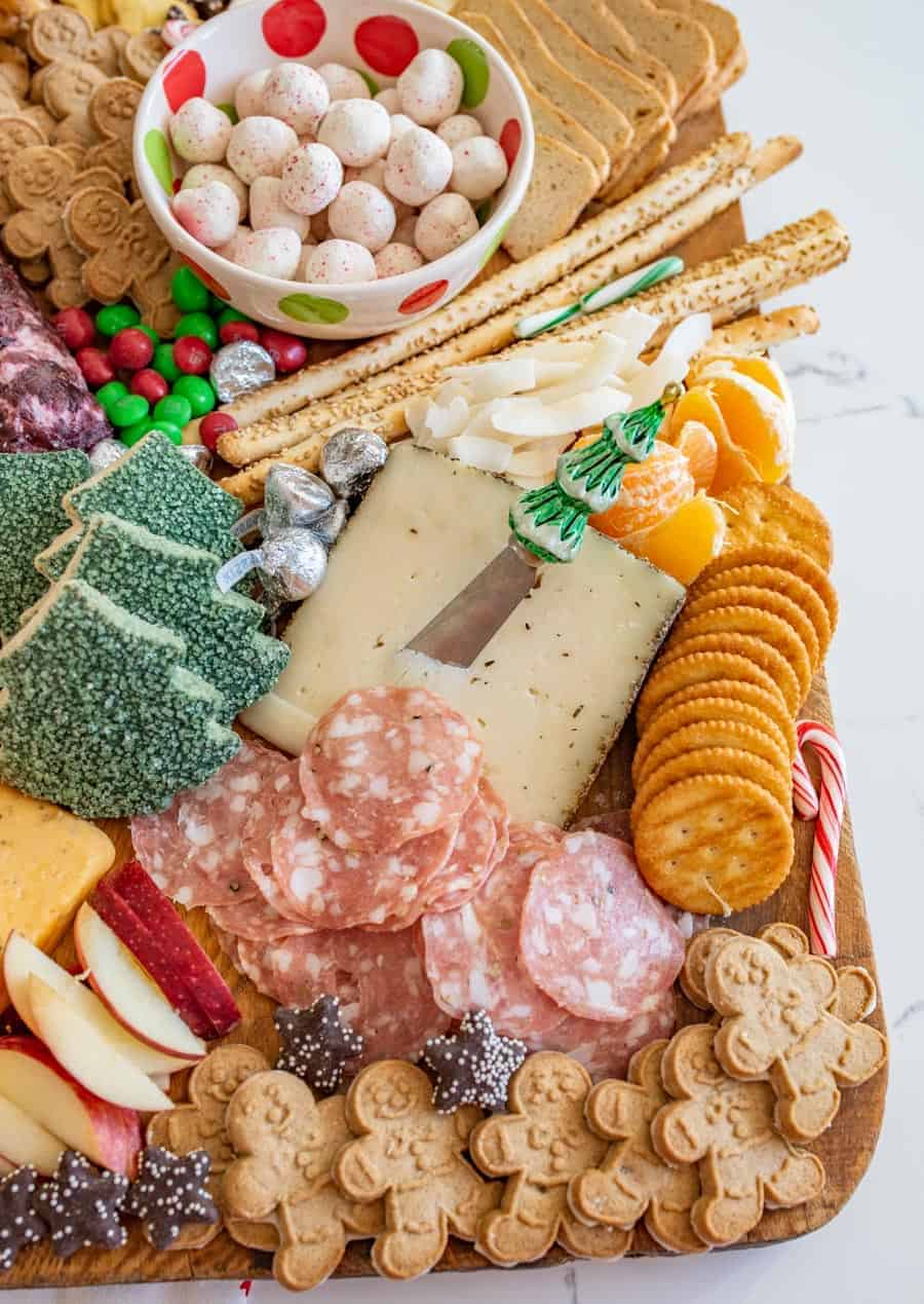 How to make a DIY Christmas Cheese board for a party complete with what cheese to buy, how to make it festive, and more!