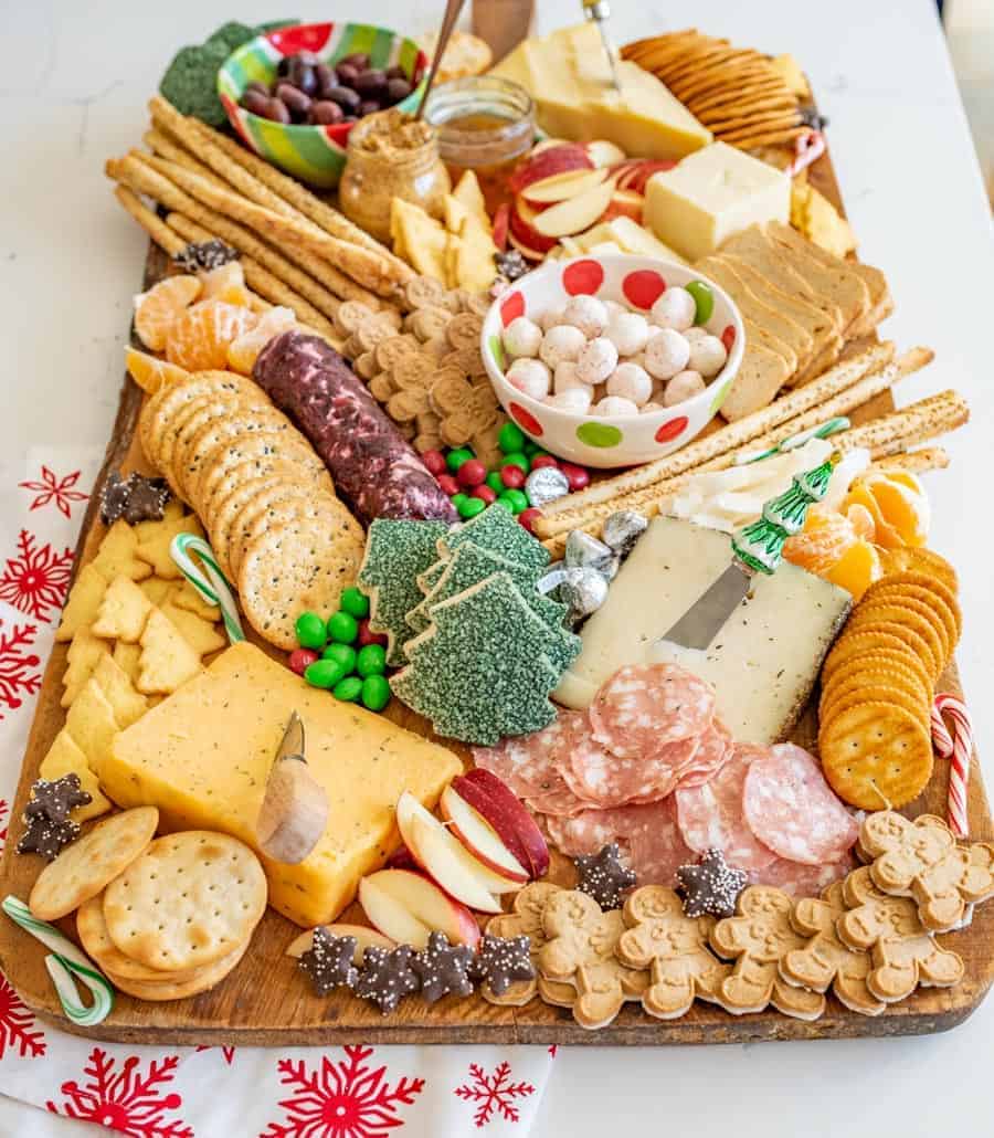 How to make a DIY Christmas Cheese board for a party complete with what cheese to buy, how to make it festive, and more!