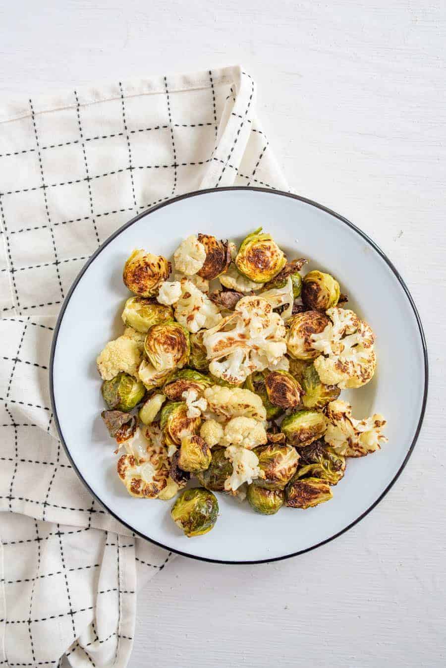 Roasted Brussels Sprouts and Cauliflower is one of our all-time favorite healthy vegetable side dishes that the whole family loves to eat. 