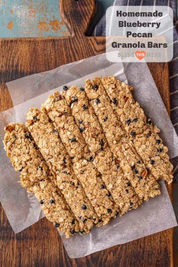 Title Image for Homemade Blueberry Pecan Granola Bars and a square of cut blueberry pecan granola bars on a wooden cutting board with wax paper