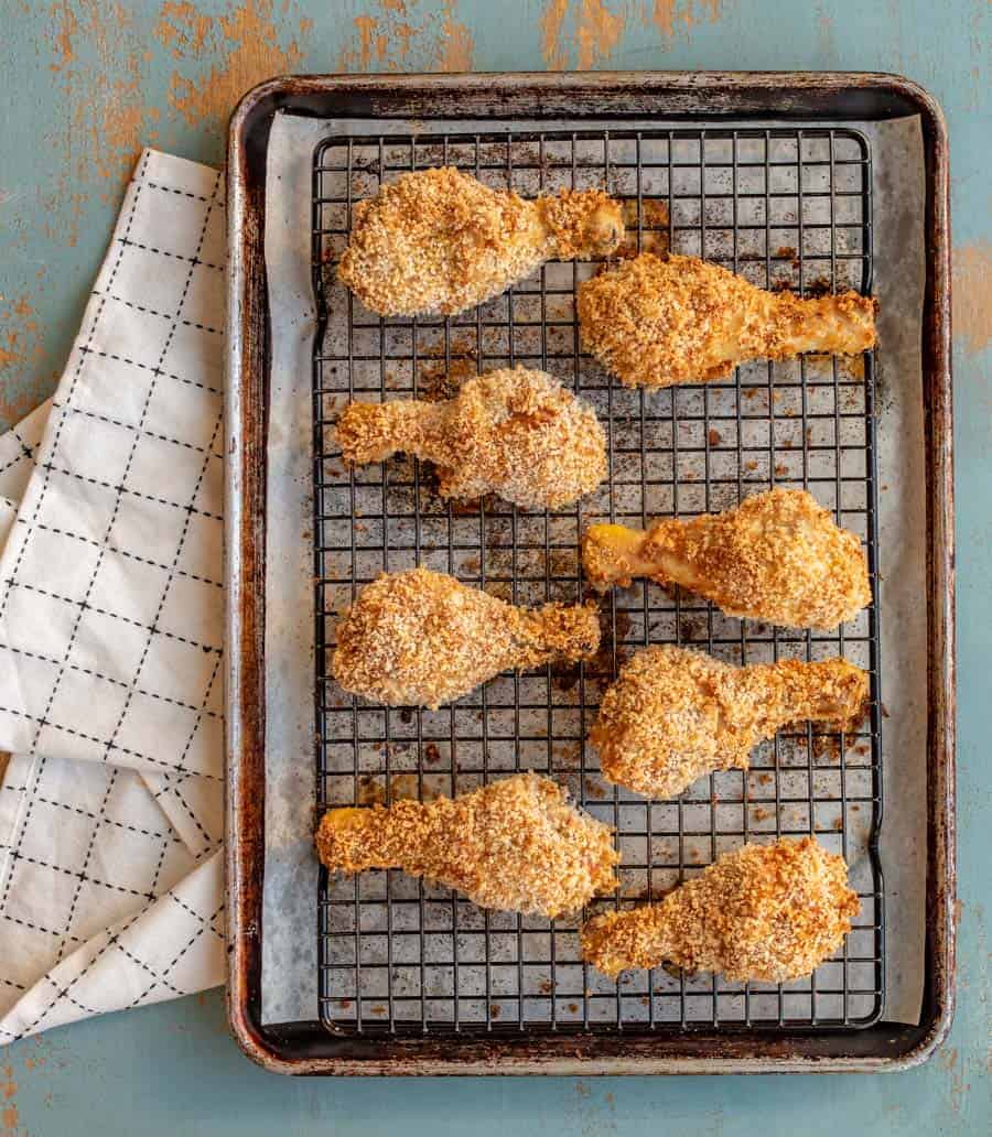 8 chicken legs evenly spaced on a pan that are golden brown and baked to crispy perfection.