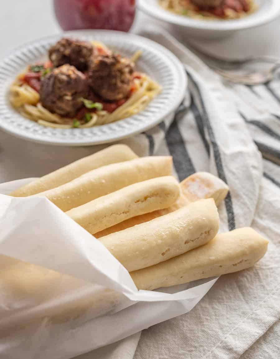 a closeup shot of a bundle of breadsticks wrapped in parchment paper.