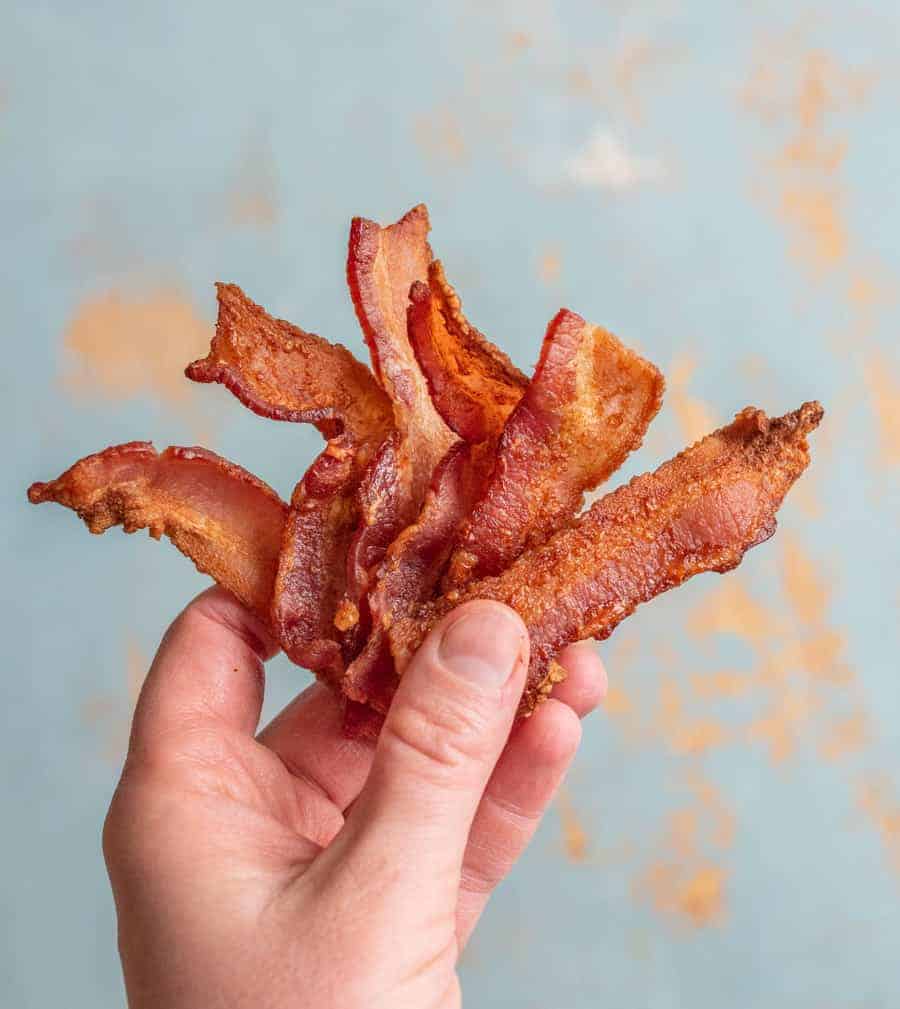 I found that thick cut bacon worked best in the air fryer as it tended to not curl up and get moved around as much by the circulating air.
