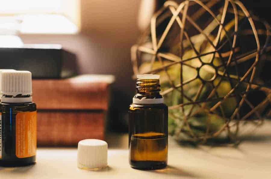 Image of a dark brown glass bottle of essential oil that is half-full. 