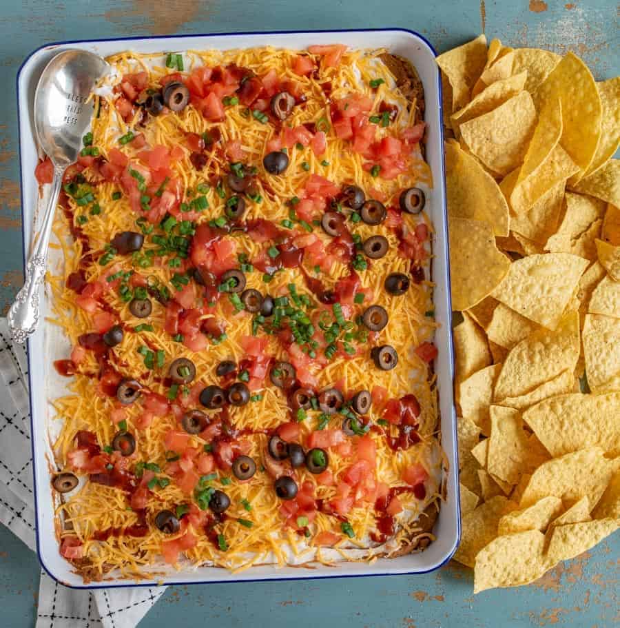 Bring the fiesta to your taste buds with this classic rendition of everyone's favorite Bean Dip. Refried beans, sour cream, cheese, tomatoes, black olives, and green onion meld with taco seasoning and salsa for a festive kick that's sure to impress.
