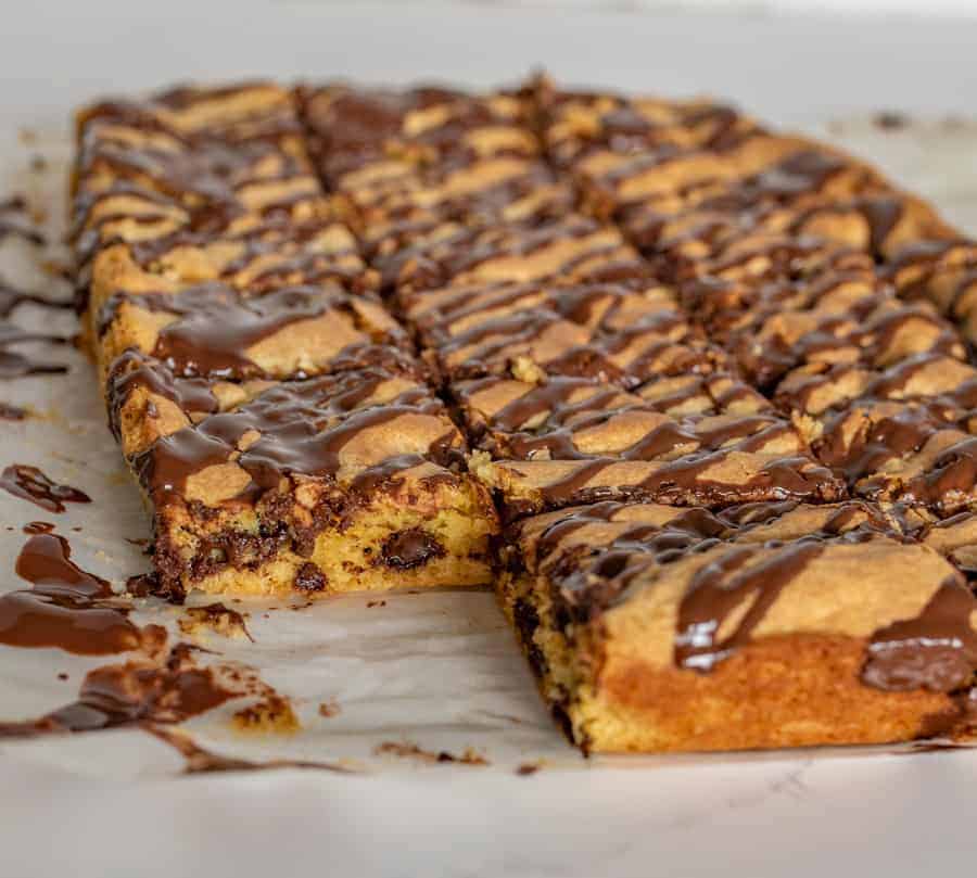 chocolate chip cookie bars on a white piece of parchment paper.