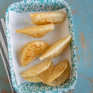 an overhead shot of corn tortilla taco shells in a pan.