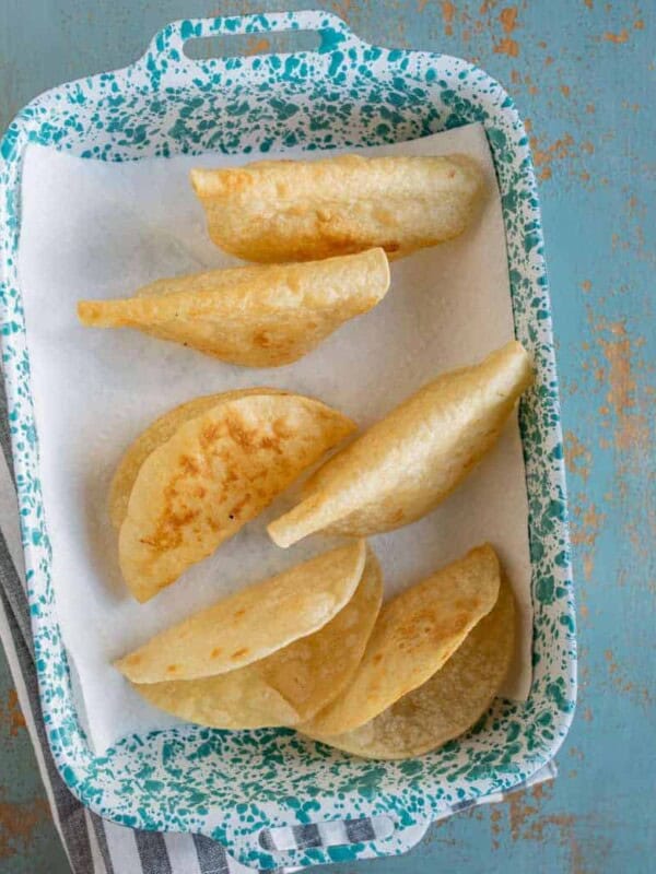 an overhead shot of corn tortilla taco shells in a pan.