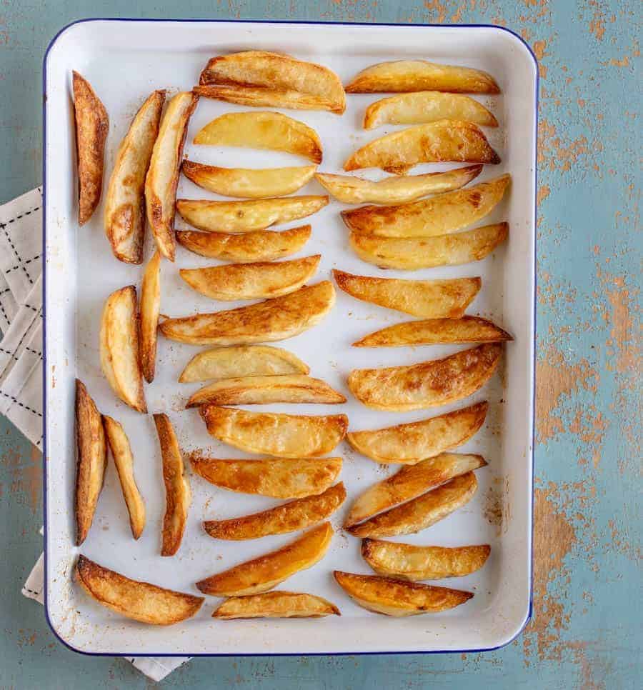 an overhead shot of oven baked French fries on a baking sheet.