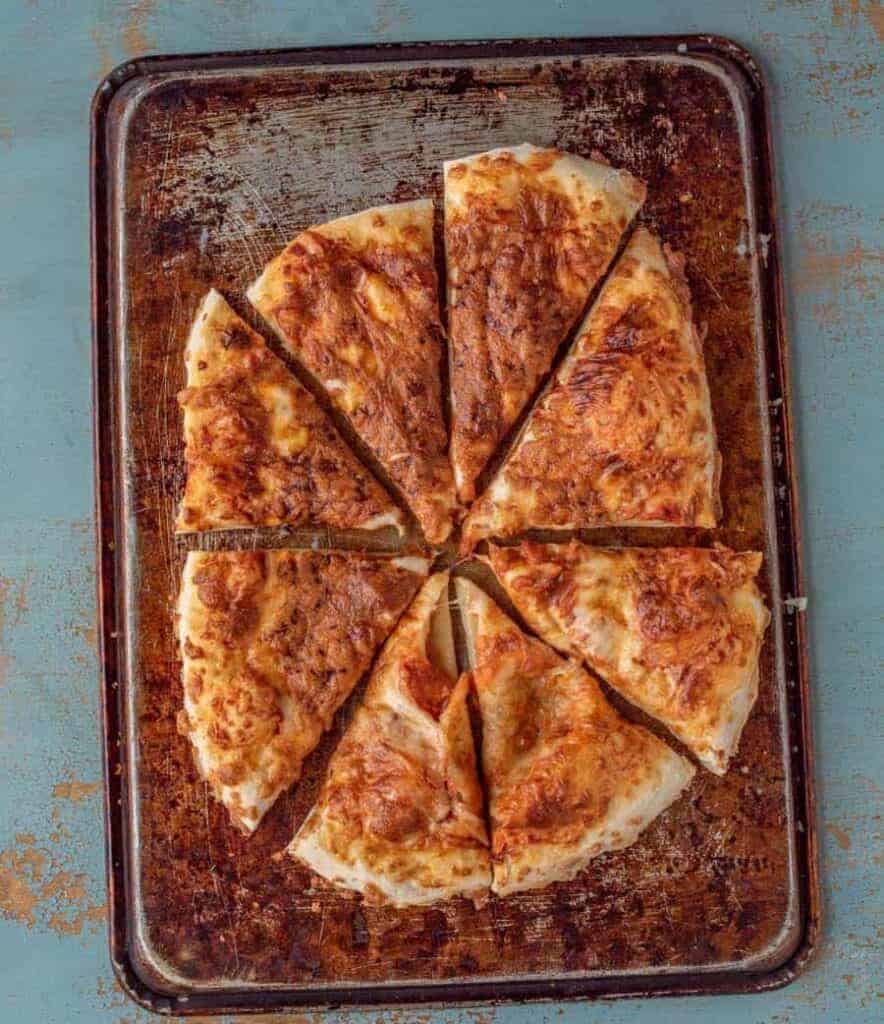 an overhead shot of no-knead pizza dough on a pan. Baked until golden brown.