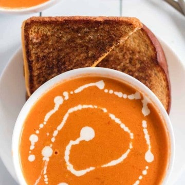 Simple Cream of Tomato Soup comes together quickly to make a creamy and lush soup with canned tomatoes, some onion and garlic, a little butter, and a few splashes of chicken broth and whole cream.