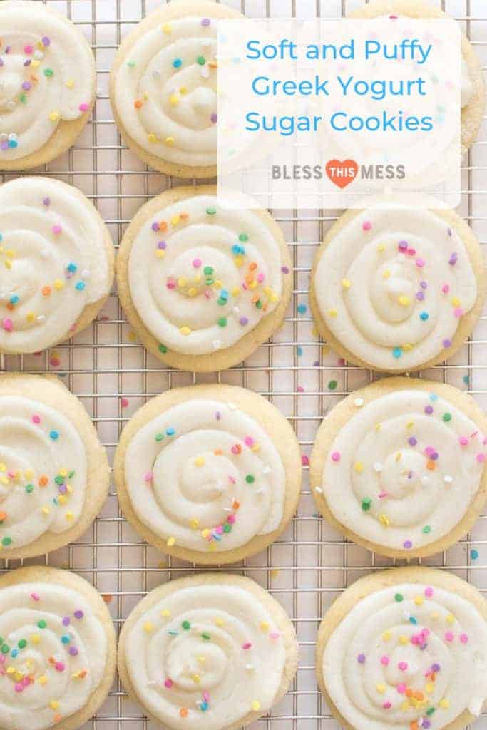 Title Image for Soft and Puffy Greek Yogurt Sugar Cookies and a dozen frosted sugar cookies with colorful sprinkles on a cooling rack