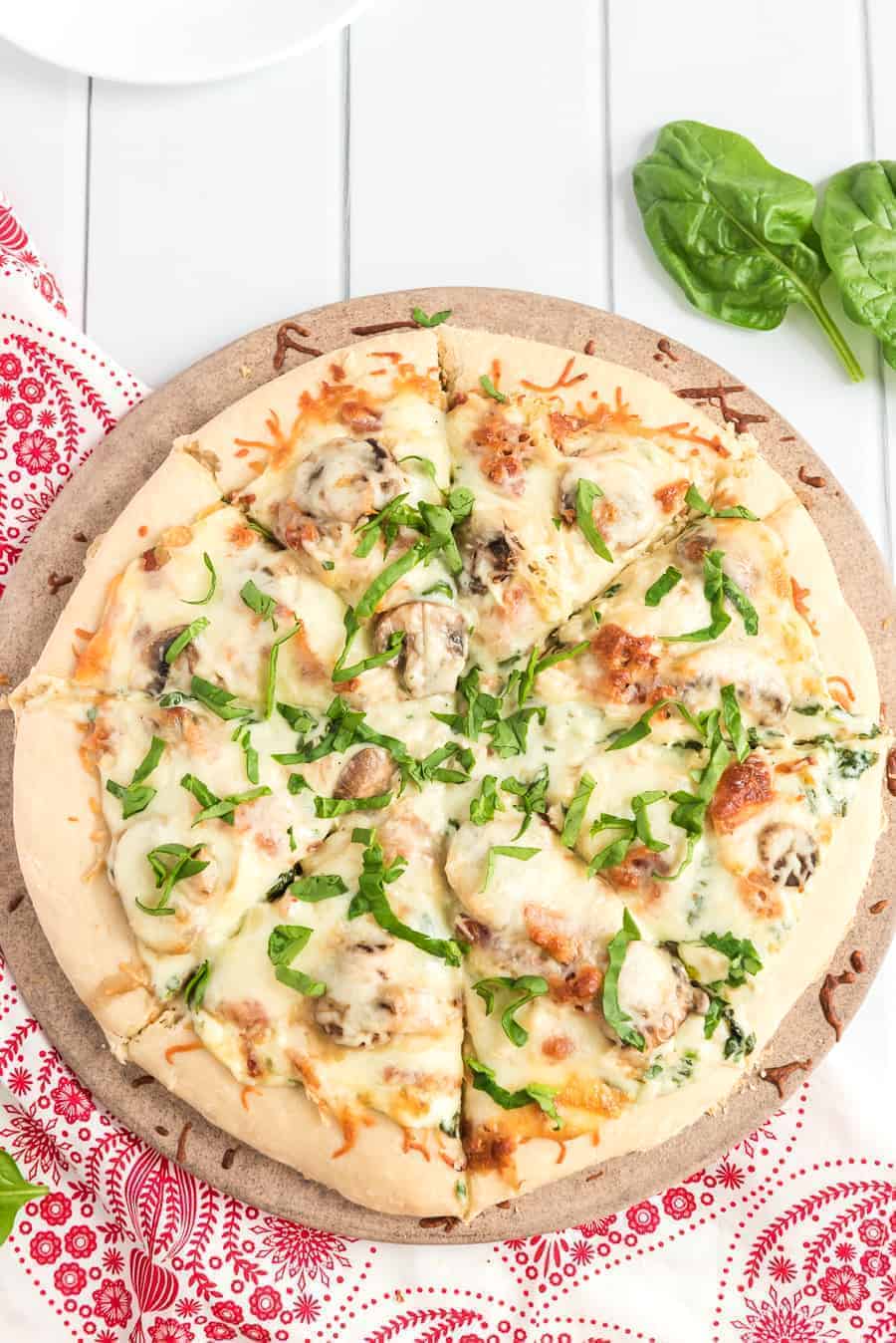 Take your homemade pizza to new heights with this recipe featuring chicken, bacon, and mushrooms slathered in melted cheese and creamy sauce.