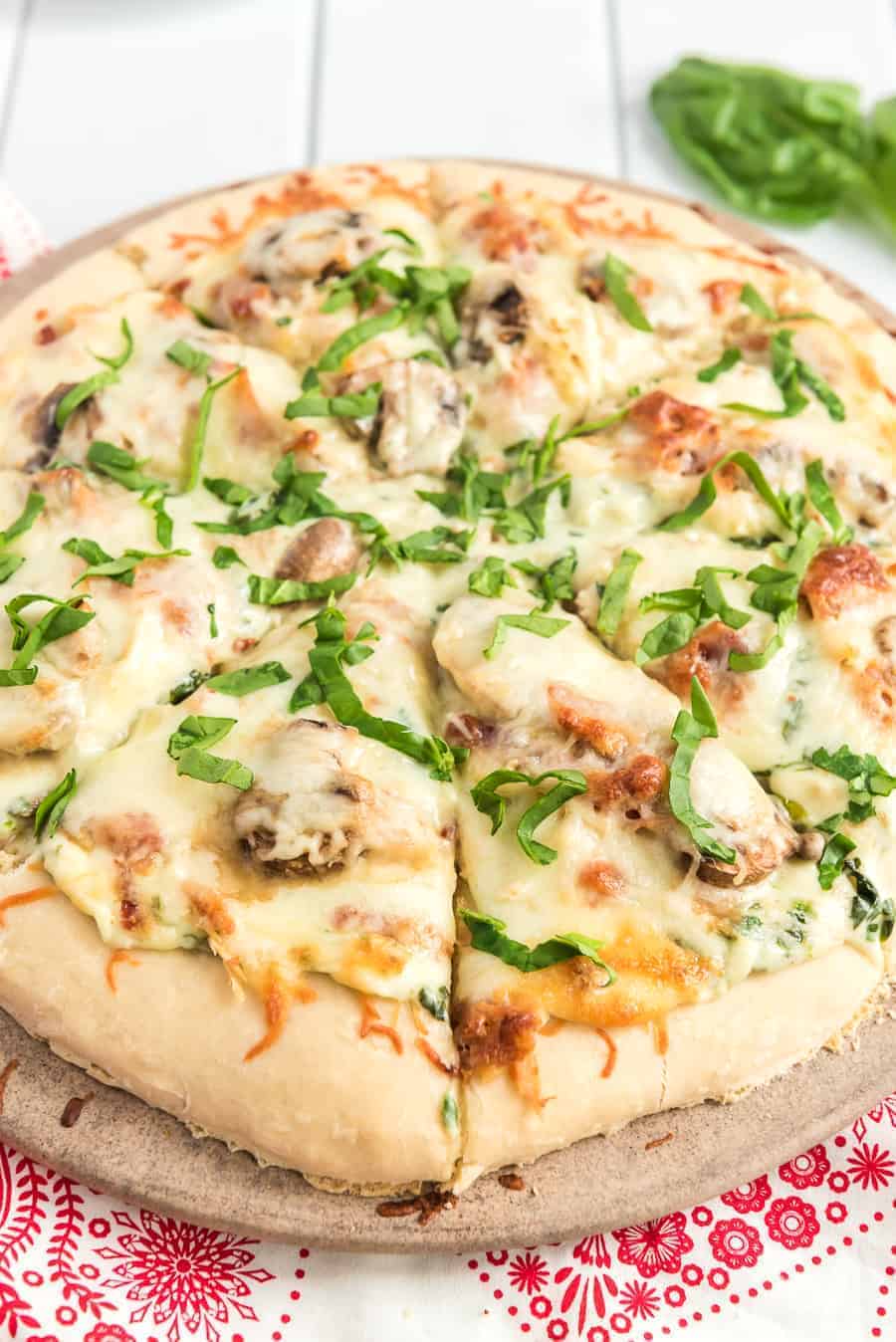 Take your homemade pizza to new heights with this recipe featuring chicken, bacon, and mushrooms slathered in melted cheese and creamy sauce.