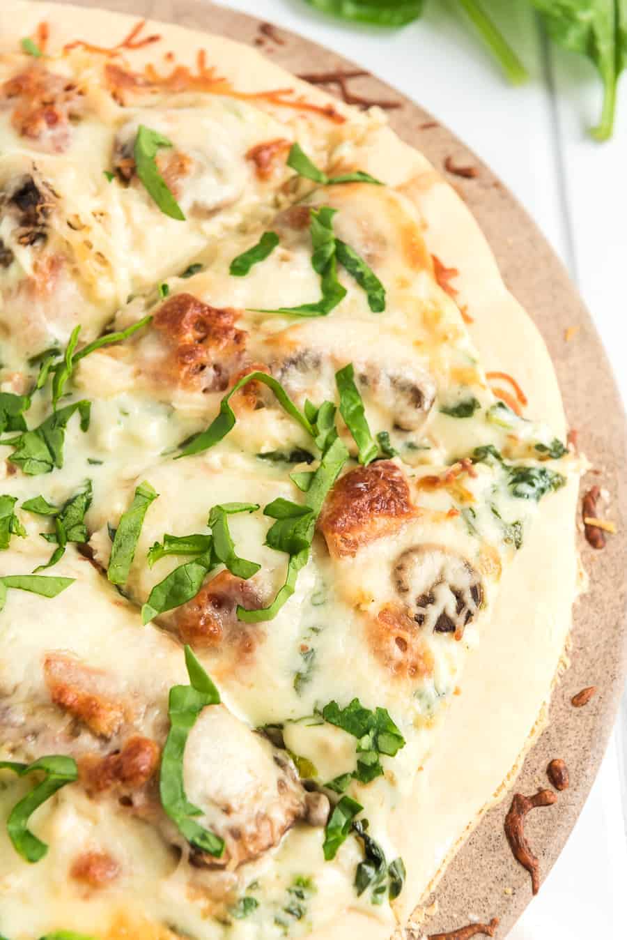 Take your homemade pizza to new heights with this recipe featuring chicken, bacon, and mushrooms slathered in melted cheese and creamy sauce.