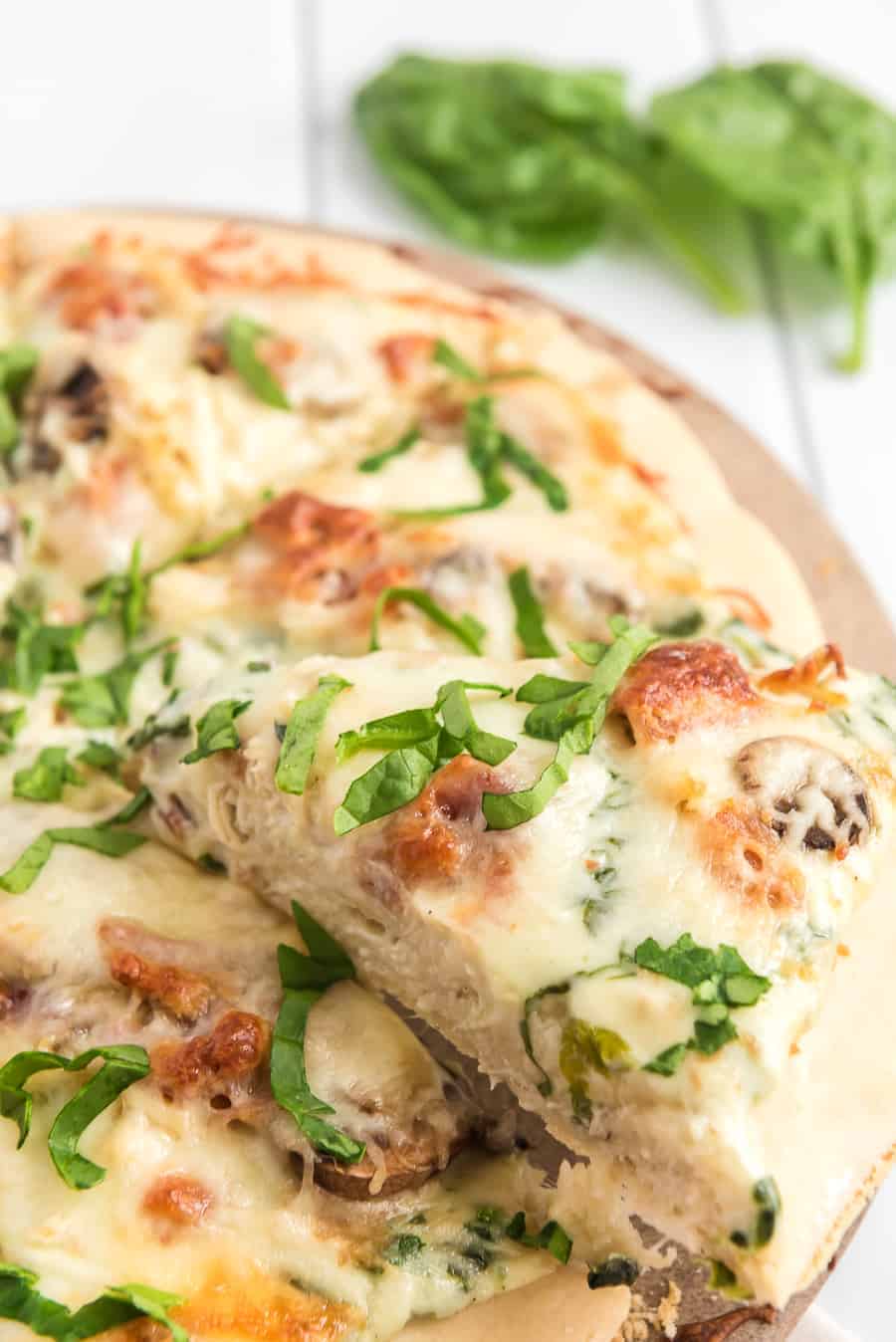 Take your homemade pizza to new heights with this recipe featuring chicken, bacon, and mushrooms slathered in melted cheese and creamy sauce.