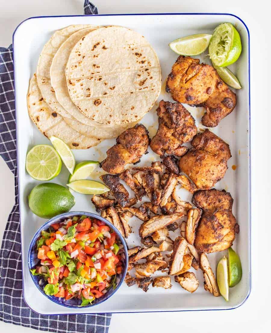 This smoky and Crispy Sheet Pan Baked Chicken Taco Meat creates tender bites of chicken thigh with the use of lime, cilantro, cumin, chili powder, and more savory spices that are perfect to wrap up in tortillas.