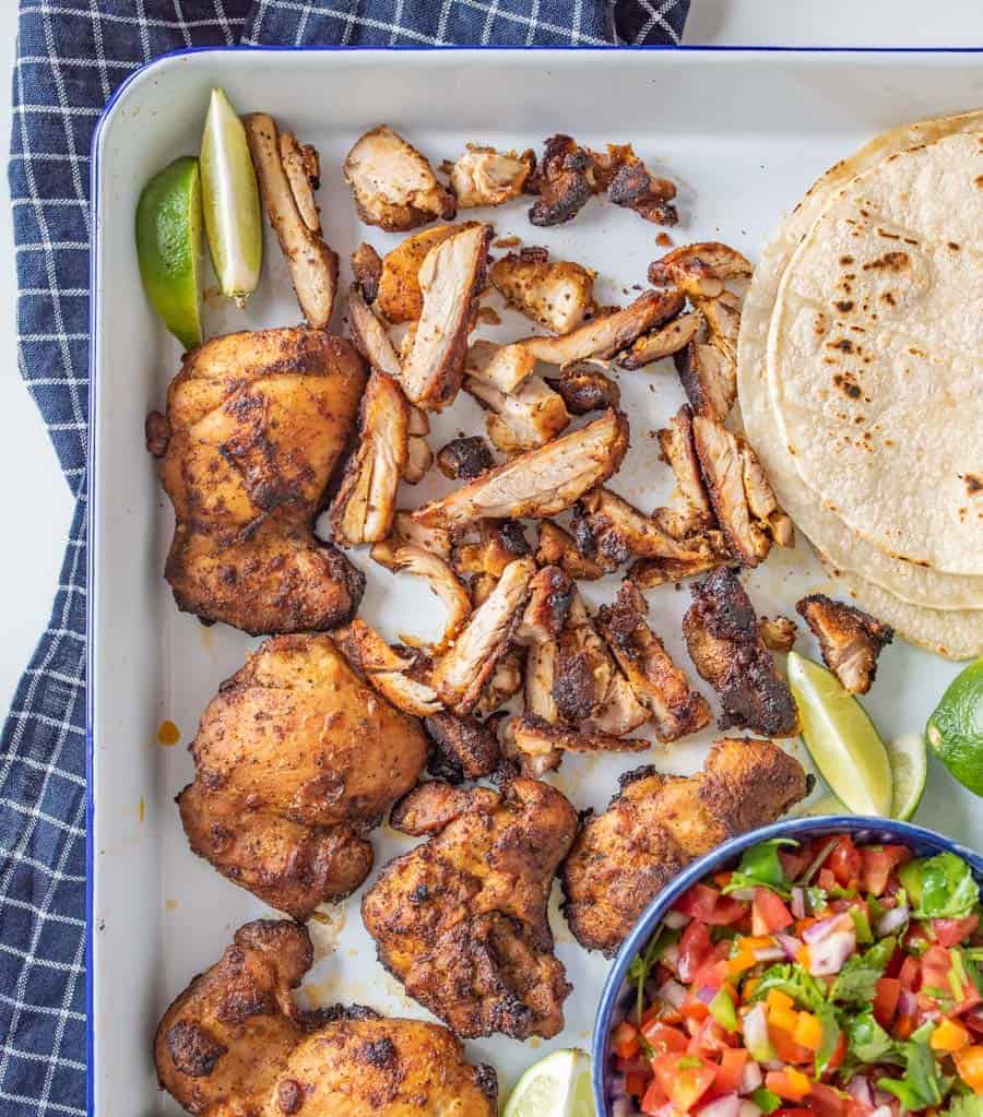 This smoky and Crispy Sheet Pan Baked Chicken Taco Meat creates tender bites of chicken thigh with the use of lime, cilantro, cumin, chili powder, and more savory spices that are perfect to wrap up in tortillas.