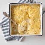 square baking dish with scalloped potatoes and a spoon