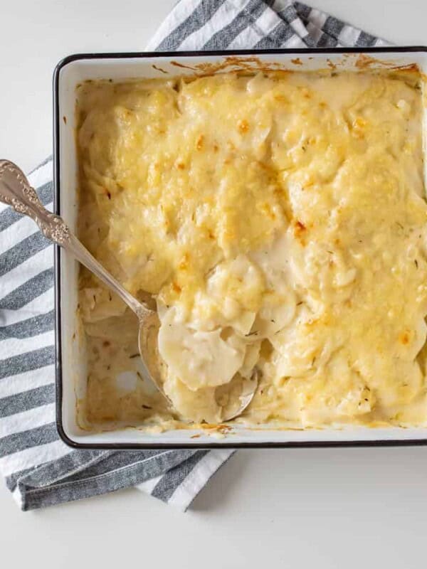 square baking dish with scalloped potatoes and a spoon