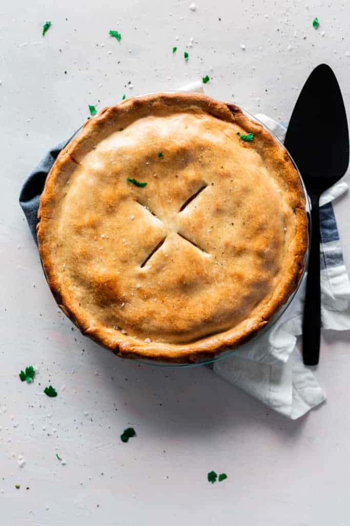 top view of whole chicken pot pie in a pie plate with a crispy golden crust