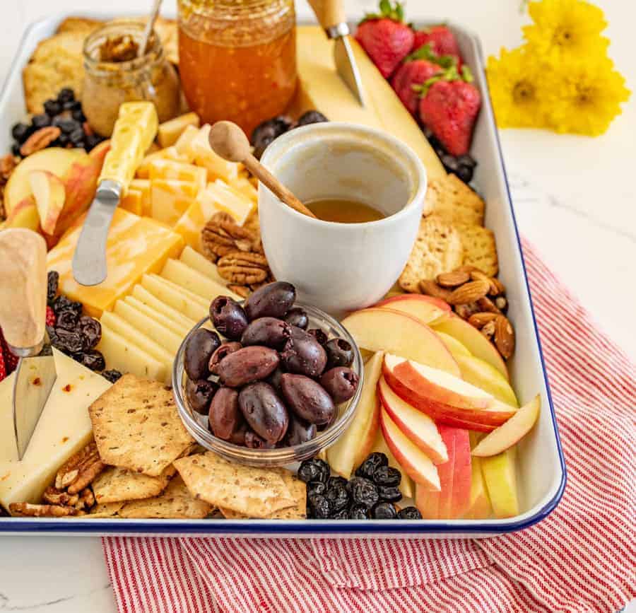 The options are endless for this Everyday Cheese Board, but the trick is to get a solid combination of flavors, textures, and colors on the board! I like cheddar, Colby jack, and Swiss cheeses with jam, mustard, various types of crackers, olives, and fruit.