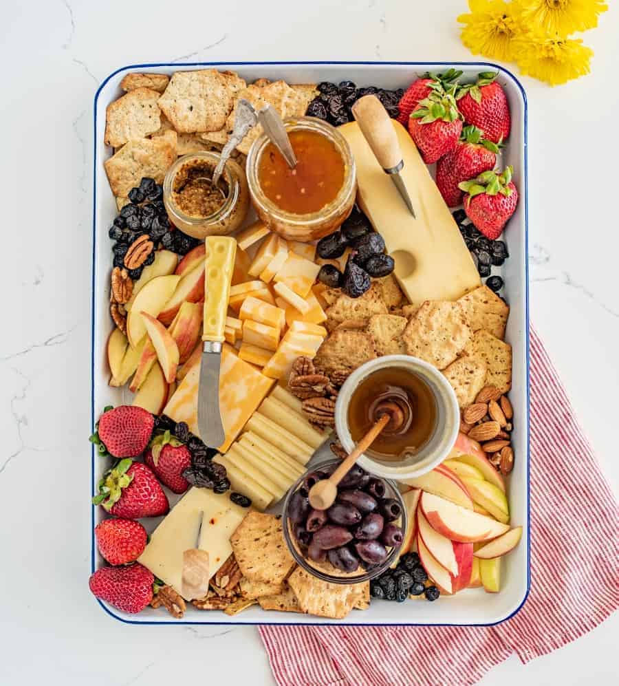 The options are endless for this Everyday Cheese Board, but the trick is to get a solid combination of flavors, textures, and colors on the board! I like cheddar, Colby jack, and Swiss cheeses with jam, mustard, various types of crackers, olives, and fruit.