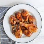 top view of sticky saucy chicken drumettes on a white plate