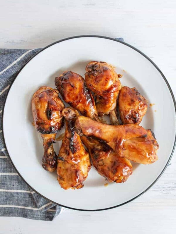 top view of sticky saucy chicken drumettes on a white plate