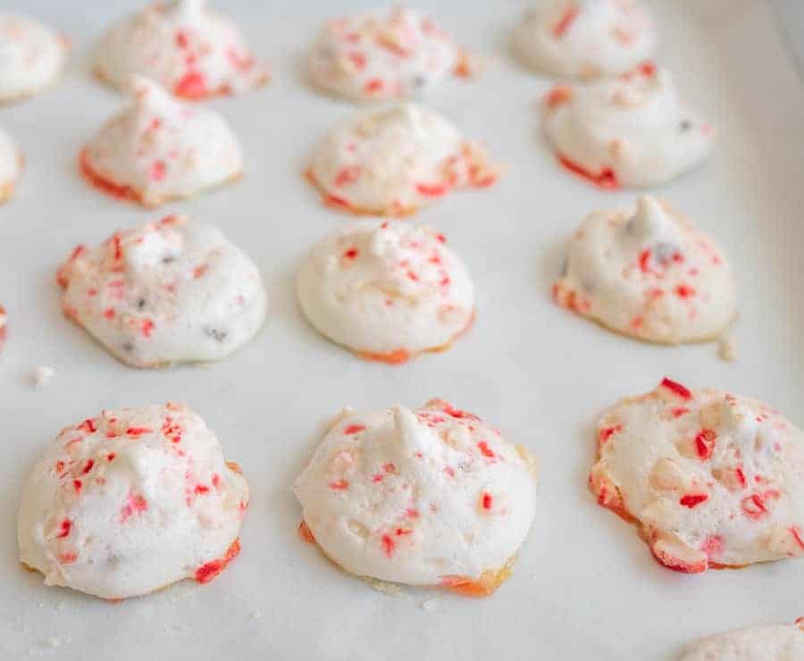 candy cane meringue cookies on a baking sheet ready for the oven.