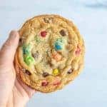 pov hand holding monster chocolate chip m and m cookies.