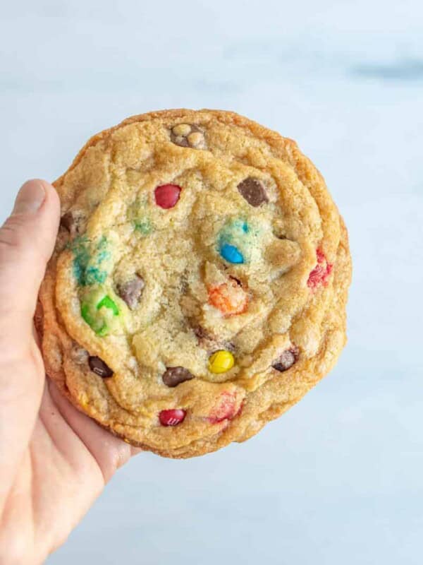 pov hand holding monster chocolate chip m and m cookies.