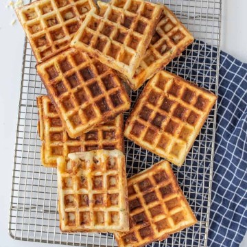 savory square waffles stacked on a cooling rack