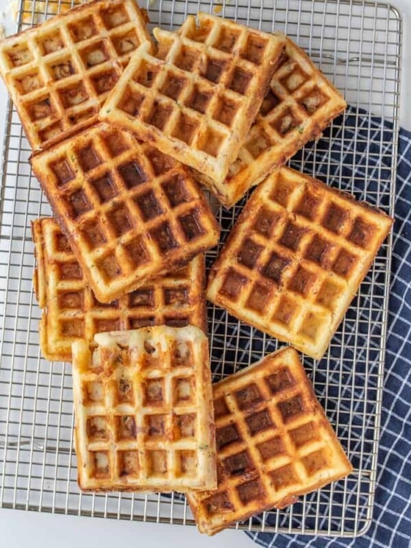 savory square waffles stacked on a cooling rack