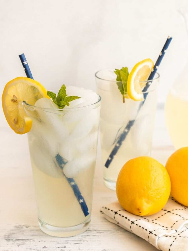 two glasses of iced homemade lemonade with blue star paper straws