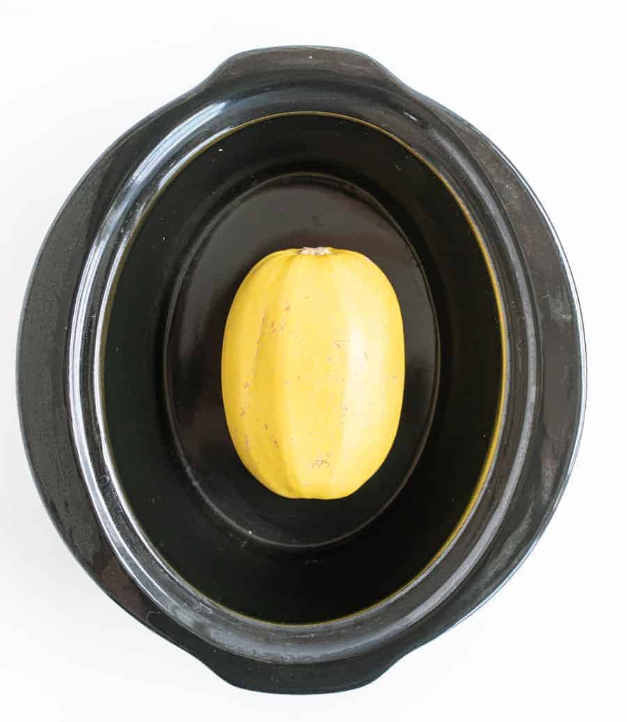 This simple recipe for how to cook a whole spaghetti squash in the slow cooker is the best set-it-and-forget-it hack -- you'll never go back to roasted spaghetti squash! #spaghettisquash #spaghetti #squash #slowcooker #crockpot