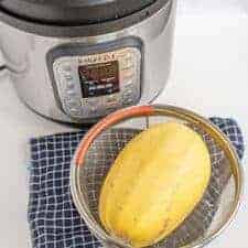 whole spaghetti squash in a strainer near the instant pot