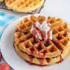 classic waffles, perfectly golden and fluffy with whipped cream and a strawberry sauce