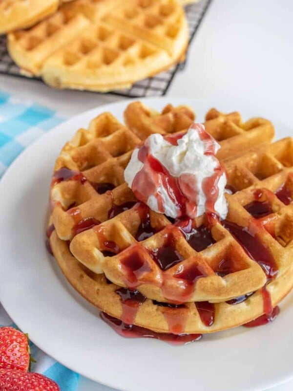 classic waffles, perfectly golden and fluffy with whipped cream and a strawberry sauce