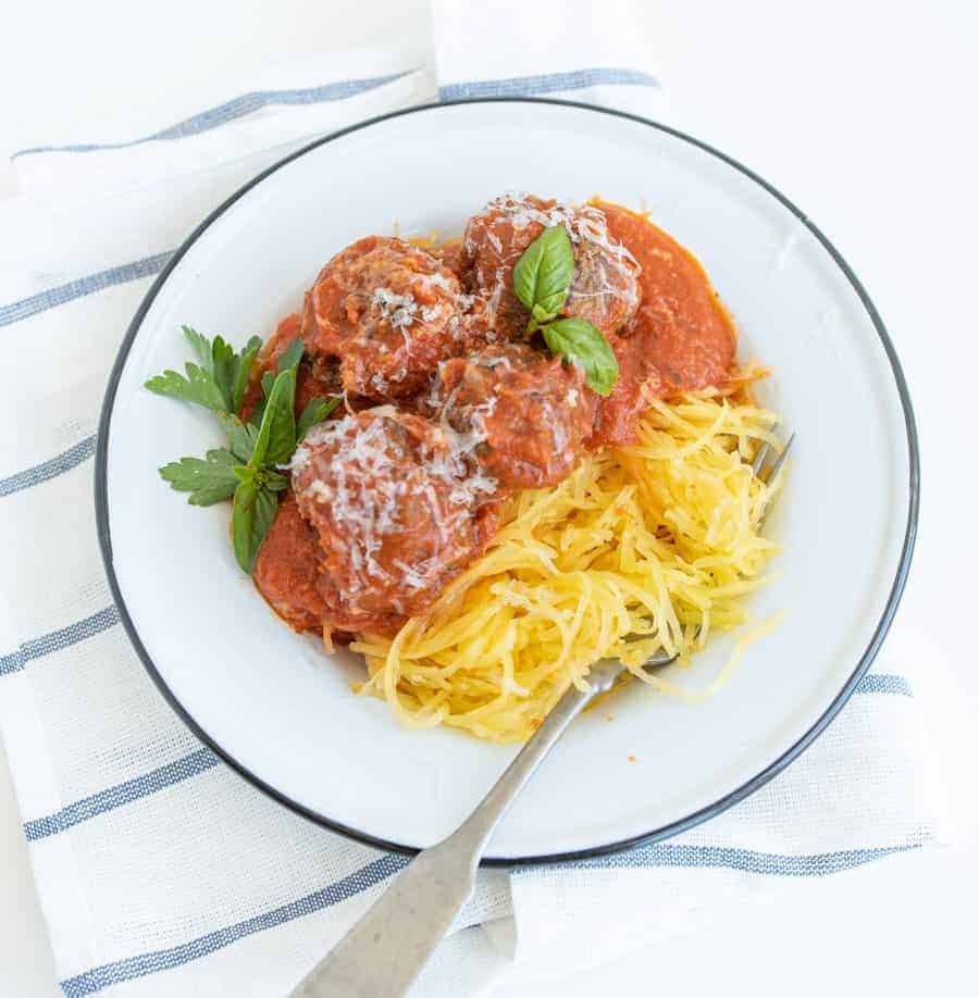 Get ready for the ultimate spaghetti and meatballs switcharoo... This spaghetti squash with meatballs and tomato sauce is just as delicious and flavorful with even more vitamins and nutrients! #spaghetti #spaghettisquash #spaghettiandmeatballs #healthypasta
