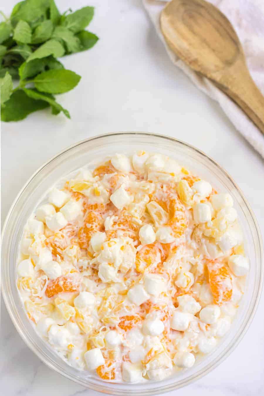This tasty and creamy 6-cup ambrosia fruit salad is the simplest thing to make and is forever a hit for kiddos and adults alike at any gathering! #ambrosiafruitsalad #fruitsalad #fruit #fruitrecipes #salad #southerndishes #fruitsaladrecipe