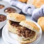 a plate of home made biscuits with ground sausage and egg in the middle