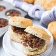 a plate of home made biscuits with ground sausage and egg in the middle