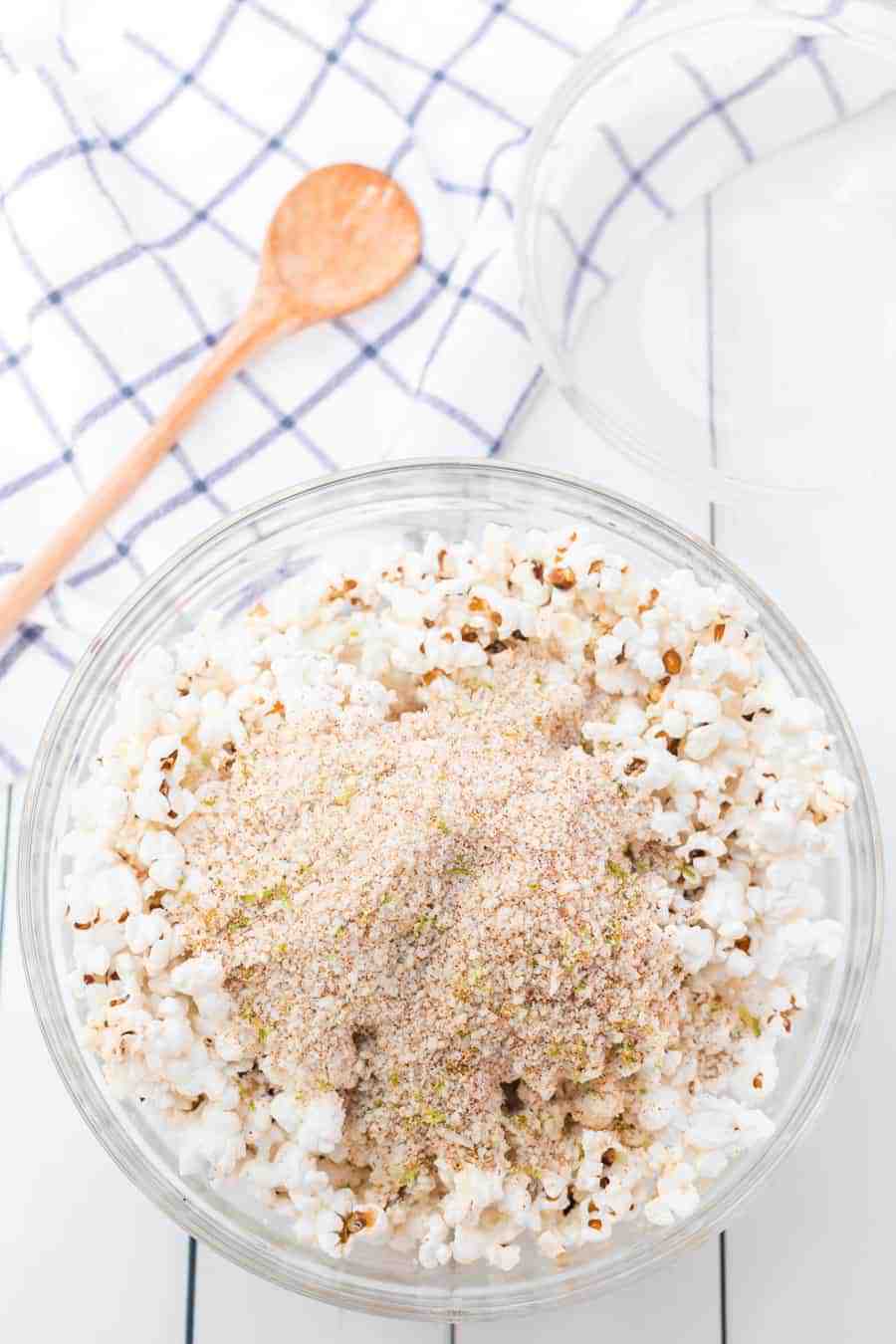 Quick and easy cheesy chili lime popcorn made with fresh popcorn, butter, cotija cheese, and chili powder make one tasty and simple snack. #popcorn #popcornrecipes #savorypopcorn #limepopcorn