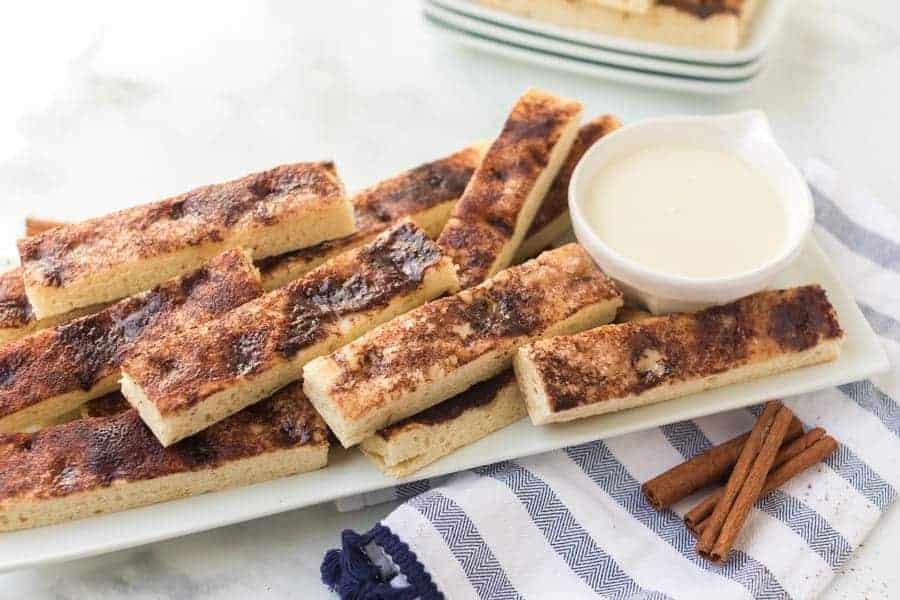 These warm, easy cinnamon sticks are SO good. They taste a lot like Pizza Hut’s cinnamon sticks, but not as greasy on the bottom. #cinnamonsticks #cinnamonbreadsticks #cinnamon #cinnamonbread #frosting #dessert