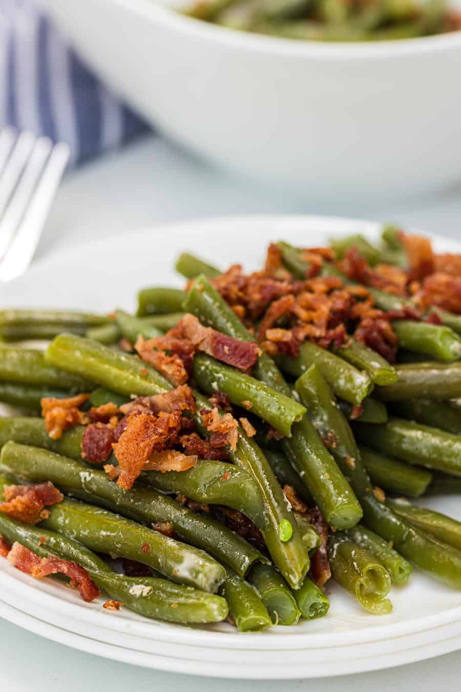 Green beans with butter and bacon is a hearty and flavor-filled side dish that takes green beans from plain to irresistible with just a handful of ingredients. #greenbeans #sides #sidedishes #veggiessides #bacon #southernsides 