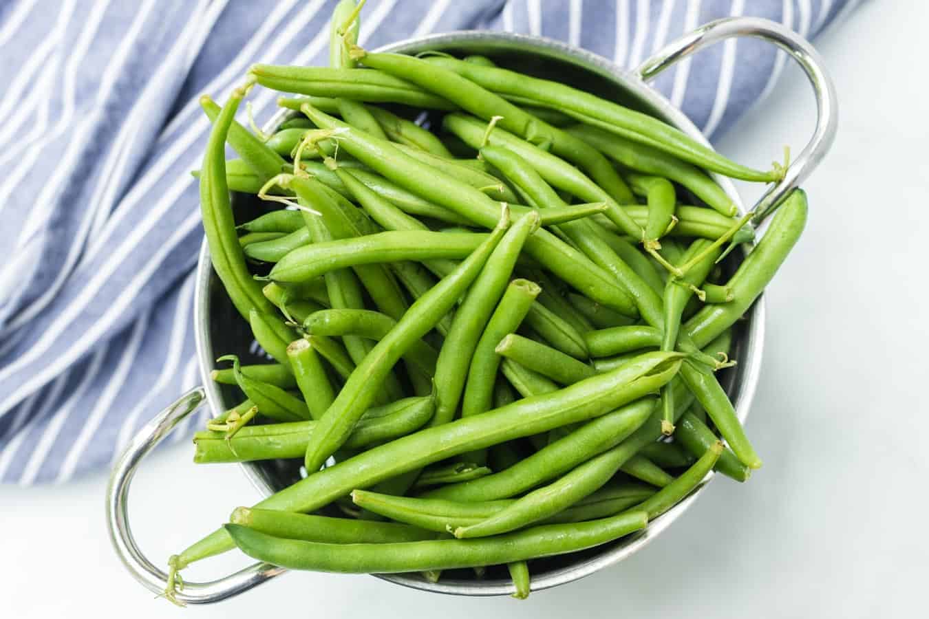freshly picked green beans in a metal colander