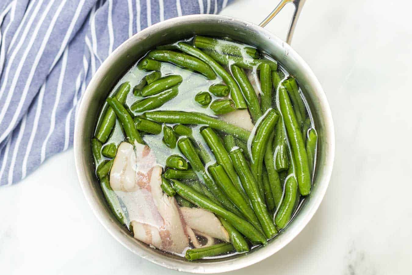 Green beans with butter and bacon is a hearty and flavor-filled side dish that takes green beans from plain to irresistible with just a handful of ingredients. #greenbeans #sides #sidedishes #veggiessides #bacon #southernsides 